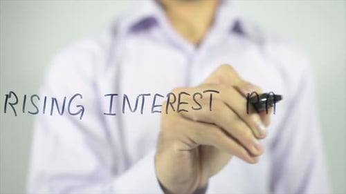 Man Writes Rising Interest Rates on Glass Surface