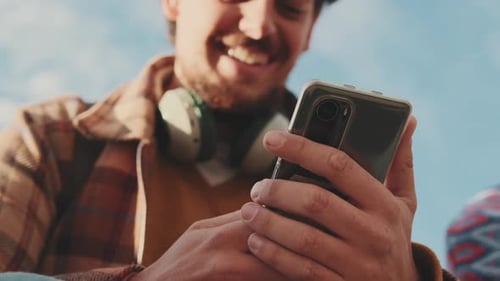 Close-up of the hands of a young man using a mobile phone
