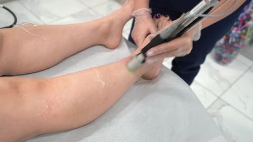 Close Up Video of Professional Cosmetologist Doing Laser Hair Removal of Legs to Young Woman in