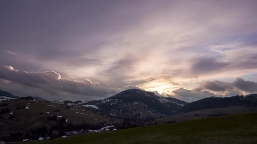 Le ciel du soir est Théâtral avec des nuages au-dessus des collines et des villages