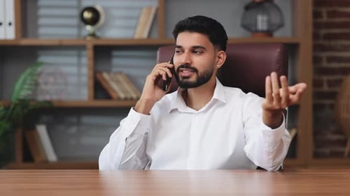 Communicative Man Talking on Phone in Office Environment