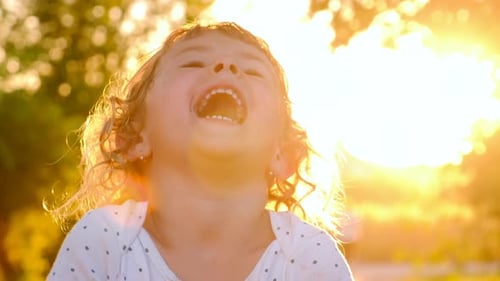 Happy Child Laughing in Golden Sunset Light