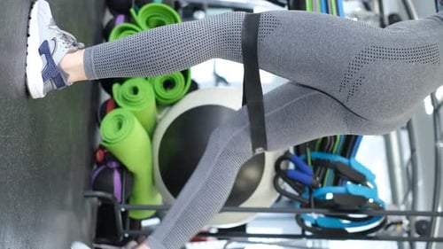 Woman Performing Leg Exercise with Resistance Band in Gym