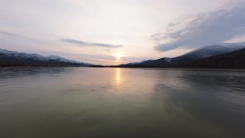 Winter River at Sunrise with Snow-Capped Mountains