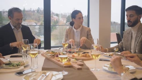 Smiling coworkers in restaurant talking during business lunch.