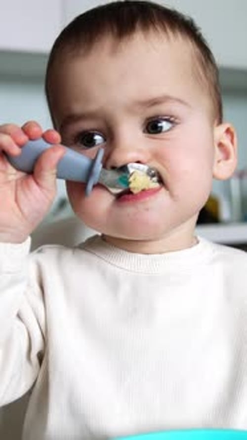 Cute Toddler Eats Lunch in High Chair