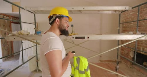 Man Using Cell Phone at Construction Site