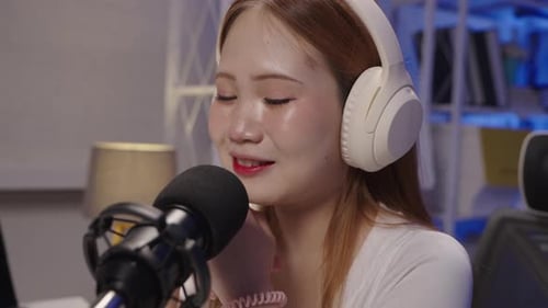 Close-up side view of podcast host speaking into microphone during live broadcast