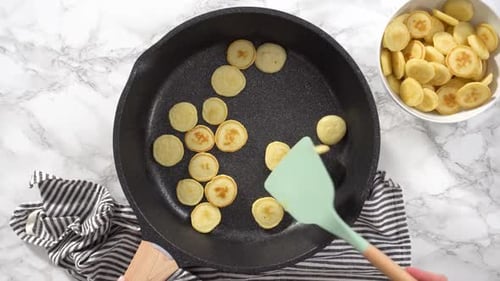 Cooking Small Pancakes in a Skillet for Breakfast