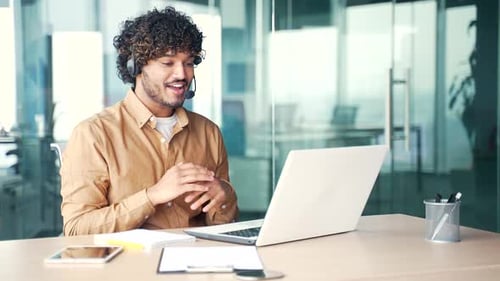 Corporate operator who works in the support service speaks on a video call using a laptop.