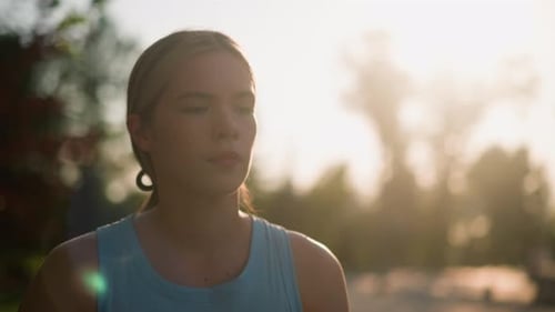 Woman Meditating in Park at Sunrise