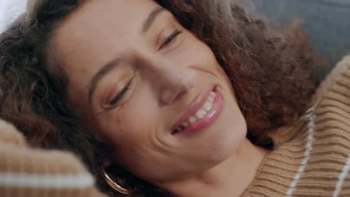 Face, phone and smile of a happy woman on a home living room lounge couch