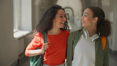 Dois estudantes hispânicos, meninas, mulheres, amigas multirraciais, mulheres, sorrindo, felizes, conversando, abraçando