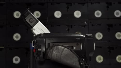 Rotating vintage retro video camera. Outdated old technology, film production.