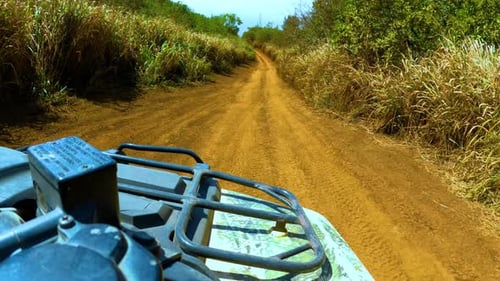 Imágenes en primera persona de andar en cuatriciclo por una carretera naranja en las montañas. El punto de vista del conductor de un recorrido en cuatrimoto
