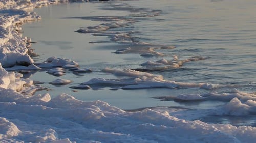 In the winter, stones are icy on the sea shore. Icicles hung from large pieces of ice