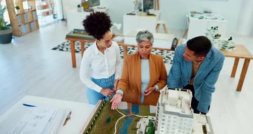 Engineering, meeting and architecture team with a model of a 3d office building