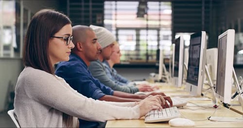 Vídeo em 4K de um grupo de estudantes universitários trabalhando em computadores em uma sala de aula