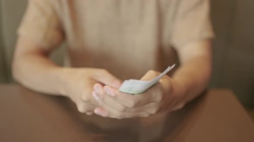 Mãos masculinas contando dinheiro para pagar juros sobre dívidas inadimplentes.