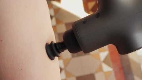 Massage Gun Treating Aching Muscles Indoors