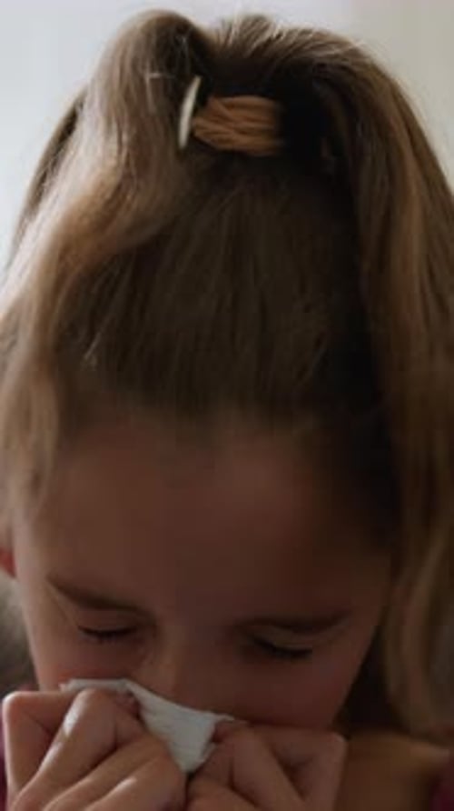 Little Girl Blowing Her Nose with Tissue Close-Up