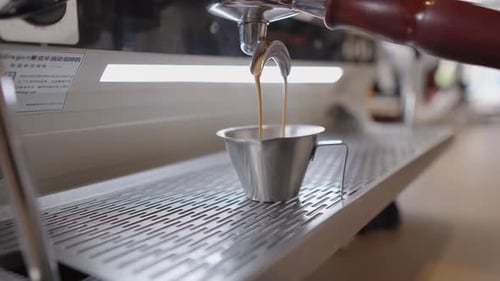 Espresso Machine Pulling Coffee into Small Metal Cup