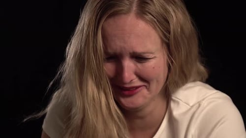 Woman Crying in Close Up Against Black Background