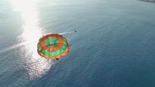 Luftaufnahme Sonnenuntergang-Silhouetten beim Parasailing vor den Farben der Abenddämmerung