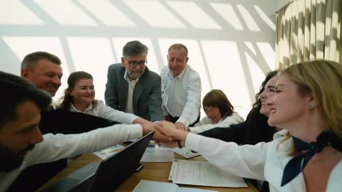 Excited Team Putting Hands Together at Office