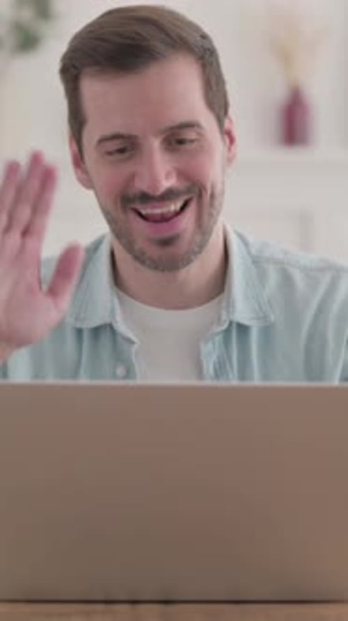 Young Man Talking on Video Call on Laptop in Office, vertical video