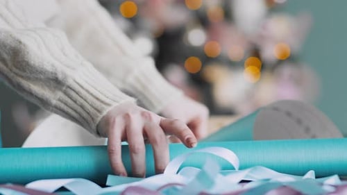 Wrapping Christmas Present with Blue Wrapping Paper