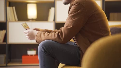 Man Counting Money Indoors Sitting on Couch