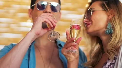 Shoot of the couple drinking champagne by the sea. model shooting.