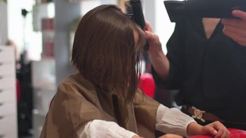 Child Getting Hair Styled by Hairdresser in Salon