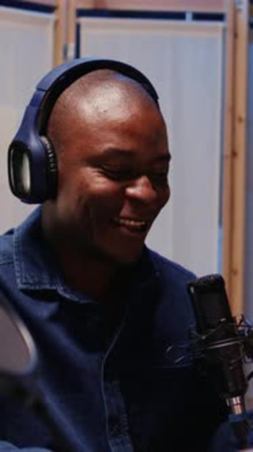 Adult Speaking Into Microphone in Broadcast Studio