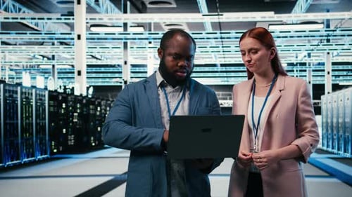 Engineering Team in Server Hub Working Together with Laptop to Do Maintenance