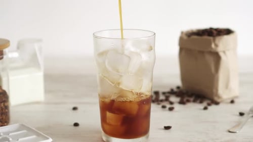Pouring Coffee Over Ice for Refreshing Drink