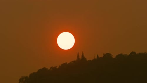 Zeitraffer des Sonnenaufgangs über wolkenbedeckten Hügeln.
