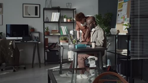 Multi-Ethnic Young Male Coworkers Discussing Details of Project in Office