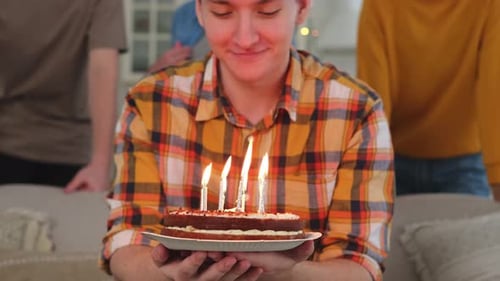 Young Adult Holds Birthday Cake With Lit Candles