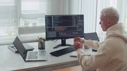 Young Man Testing Scripts on Digital Devices at Office