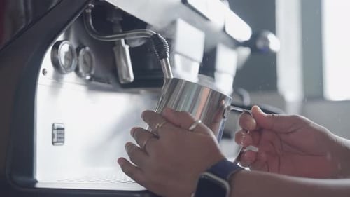 Foaming of milk by a coffee at a coffee shop