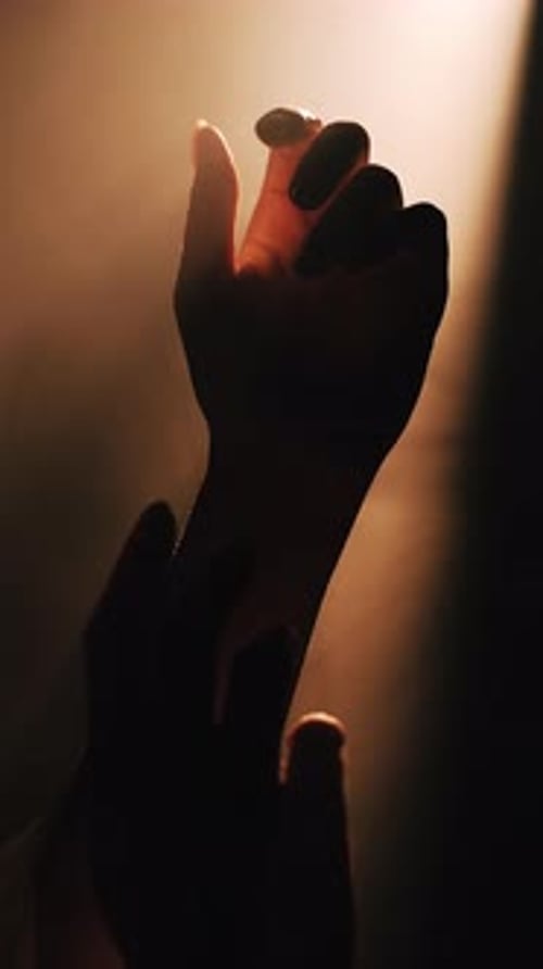 Hands Reaching Towards Light Source Silhouette