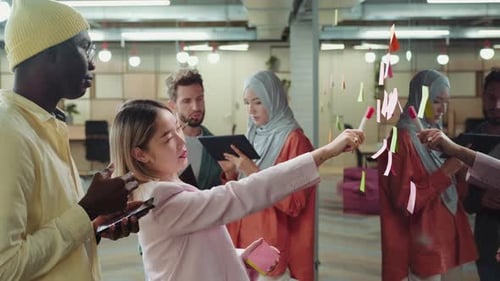 Diverse Team Brainstorming Ideas on Glass Wall