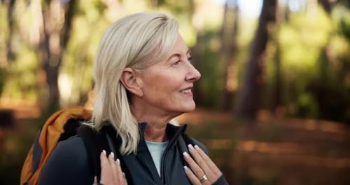 Hiking, senior woman and walking in forest for adventure, retirement hobby and cardio wellness