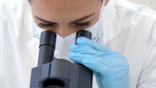 Focused Woman Scientist Working With Microscope in Lab