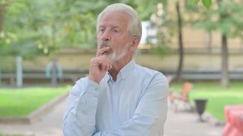 Thoughtful Senior Man Pondering in Urban Park
