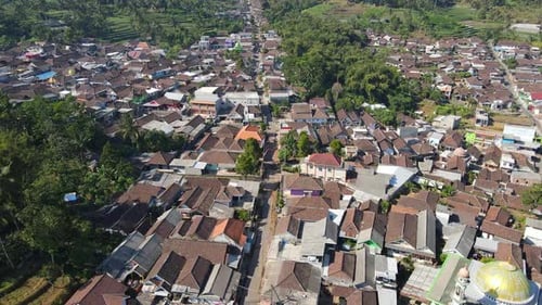 4K aerial footage showcasing a scenic countryside with vast green fields and a towering mountain bac