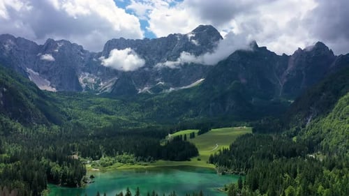 Picturesque lake Lago Fusine in Italy. Fusine lake with Mangart peak on background. Popular travel d