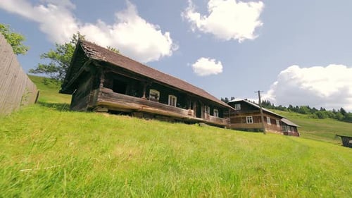 Old Wooden Houses and Green Grass on Sunny Day
